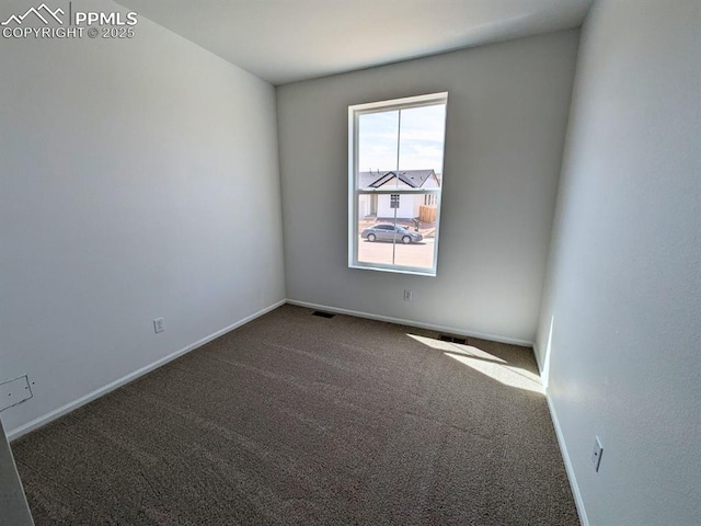 spare room with carpet, baseboards, and visible vents
