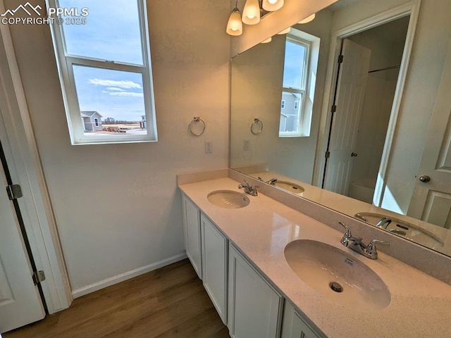 full bath featuring a sink, a healthy amount of sunlight, and wood finished floors