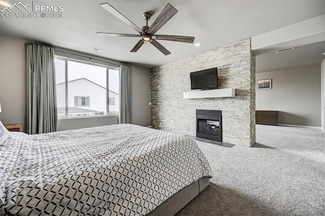 10790 Rolling Peaks Dr, Peyton, CO 80831 - carpeted bedroom with a textured ceiling, ceiling fan, and a stone fireplace