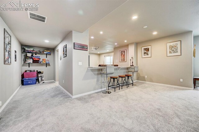 10790 Rolling Peaks Dr, Peyton, CO 80831 - kitchen with carpet floors, recessed lighting, a breakfast bar, and visible vents