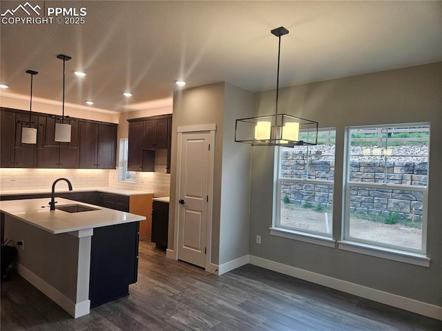 16207 Talons Bluff Ln, Monument, CO 80132 - kitchen with backsplash, dark wood-style floors, dark brown cabinets, recessed lighting, and a chandelier