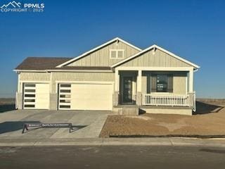 view of front facade featuring an attached garage, driveway, and a porch