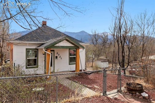 2721 W Bijou St, Colorado Springs, CO 80904 - view of front of home with a porch, a chimney, a mountain view, a fenced front yard, and a gate