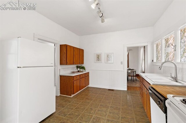 2721 W Bijou St, Colorado Springs, CO 80904 - kitchen featuring white appliances, a sink, brown cabinetry, light countertops, and a wainscoted wall