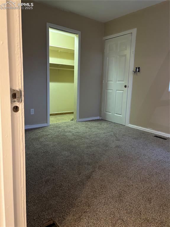 carpeted empty room with baseboards