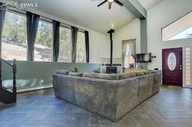 5581 County Road 328, Westcliffe, CO 81252 - living area with a baseboard heating unit, a wood stove, high vaulted ceiling, and ceiling fan