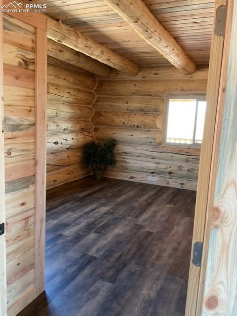 1906 Korlkoff Ln, Fort Garland, CO 81133 - spare room with beamed ceiling, dark wood-type flooring, log walls, and wooden ceiling