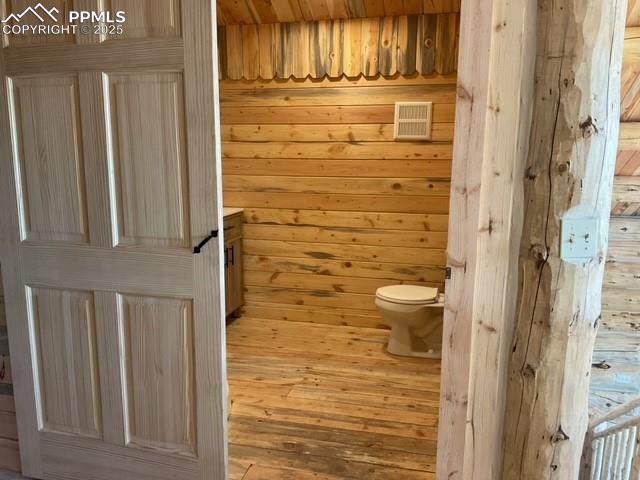 1906 Korlkoff Ln, Fort Garland, CO 81133 - bathroom featuring visible vents, wooden walls, and toilet