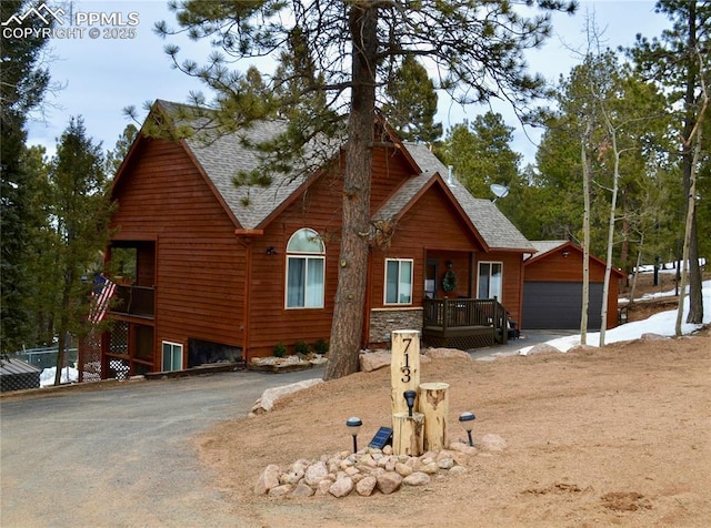 view of front of home featuring an outdoor structure and roof with shingles