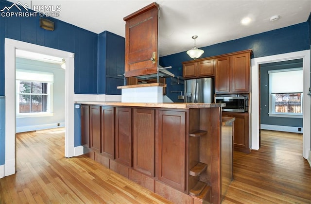 3010 W Kiowa St, Colorado Springs, CO 80904 - kitchen with pendant lighting, wood finished floors, appliances with stainless steel finishes, a peninsula, and baseboards