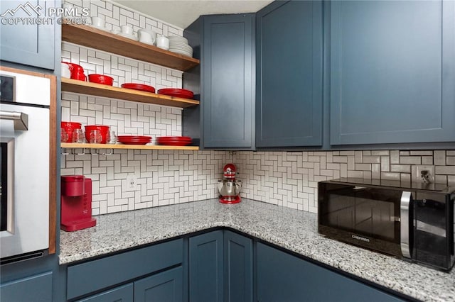 326 Columbine St, Fountain, CO 80817 - kitchen featuring blue cabinetry, stainless steel oven, open shelves, decorative backsplash, and light stone counters