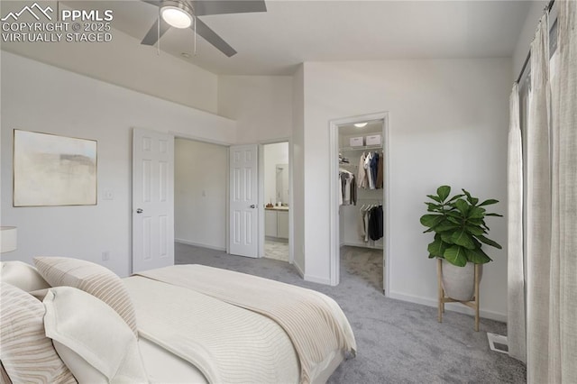 bedroom with a closet, carpet flooring, a walk in closet, baseboards, and visible vents