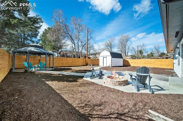 view of yard with a fire pit, a gazebo, an outdoor structure, a patio, and a storage unit