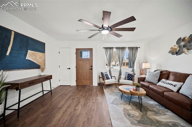 living area featuring baseboards, ceiling fan, and wood finished floors