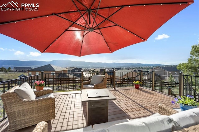 wooden deck featuring a mountain view and an outdoor fire pit