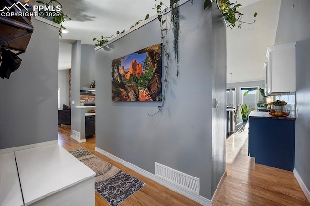 hallway featuring light wood-type flooring and baseboards