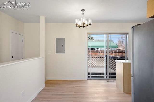 2118 S El Paso Ave, Colorado Springs, CO 80905 - unfurnished dining area with baseboards, light wood-type flooring, electric panel, and a notable chandelier