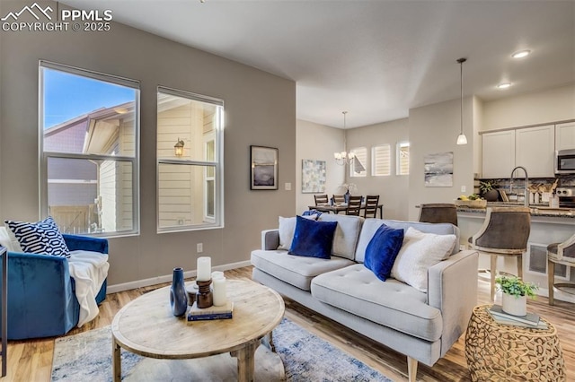 1341 Solitaire St, Colorado Springs, CO 80905 - living area featuring baseboards, light wood-style floors, recessed lighting, and an inviting chandelier