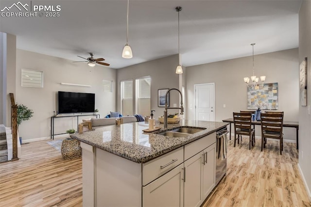 1341 Solitaire St, Colorado Springs, CO 80905 - kitchen with open floor plan, light stone counters, light wood-style flooring, and a sink