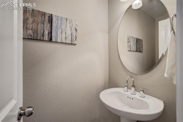 1341 Solitaire St, Colorado Springs, CO 80905 - bathroom with a textured wall and a sink