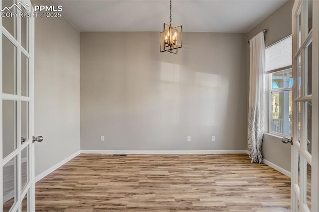 1341 Solitaire St, Colorado Springs, CO 80905 - unfurnished room with baseboards, french doors, an inviting chandelier, and light wood finished floors