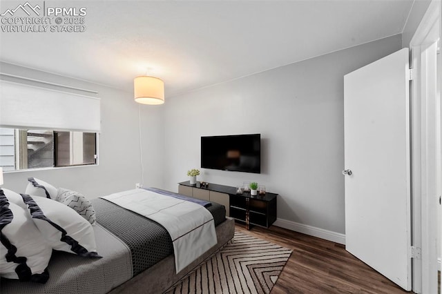 bedroom with wood finished floors and baseboards