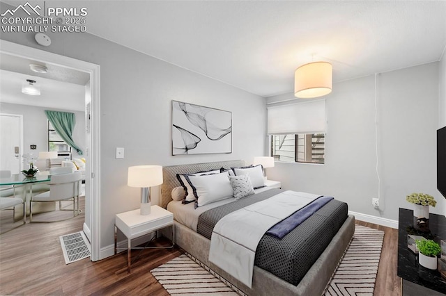 bedroom featuring wood finished floors and baseboards