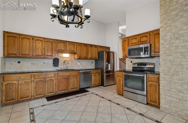 5865 Waterfall Loop, Manitou Springs, CO 80829 - kitchen with a sink, appliances with stainless steel finishes, a towering ceiling, and brown cabinets