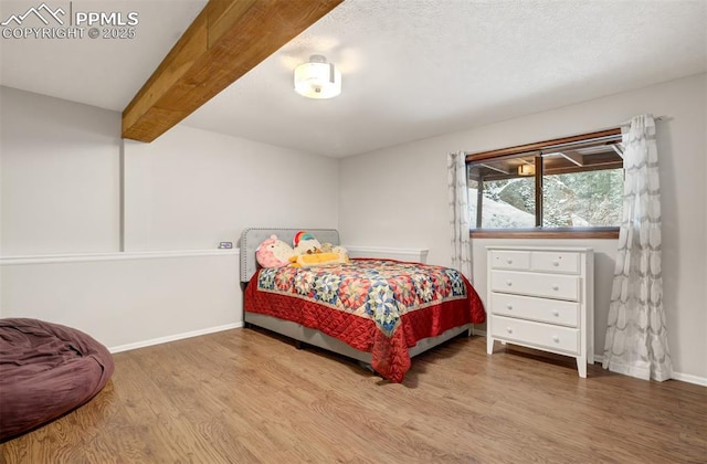5865 Waterfall Loop, Manitou Springs, CO 80829 - bedroom featuring baseboards, a textured ceiling, wood finished floors, and beamed ceiling