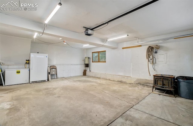 5865 Waterfall Loop, Manitou Springs, CO 80829 - garage with a wood stove, a garage door opener, fridge, and freestanding refrigerator
