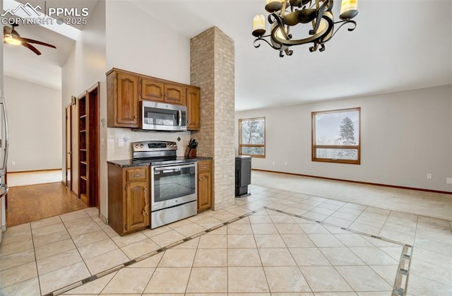 5865 Waterfall Loop, Manitou Springs, CO 80829 - kitchen with ceiling fan with notable chandelier, brown cabinetry, light tile patterned floors, and appliances with stainless steel finishes