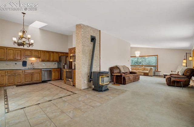 5865 Waterfall Loop, Manitou Springs, CO 80829 - kitchen with open floor plan, a wood stove, an inviting chandelier, a sink, and appliances with stainless steel finishes
