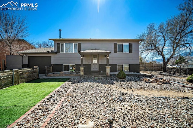 2219 Sonoma Dr, Colorado Springs, CO 80910 - view of front of house with a front lawn, fence, and an attached garage