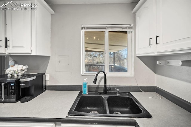 2219 Sonoma Dr, Colorado Springs, CO 80910 - kitchen featuring white cabinets, a sink, and black microwave