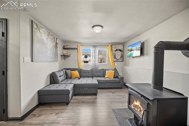 2219 Sonoma Dr, Colorado Springs, CO 80910 - living room featuring a textured wall, a textured ceiling, wood finished floors, and a wood stove
