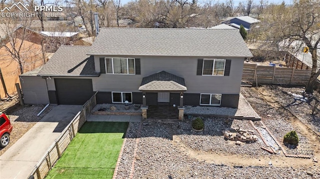 2219 Sonoma Dr, Colorado Springs, CO 80910 - view of front facade with driveway, a shingled roof, fence, and an attached garage