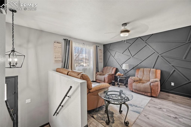2219 Sonoma Dr, Colorado Springs, CO 80910 - living area featuring a decorative wall, ceiling fan with notable chandelier, an accent wall, and wood finished floors