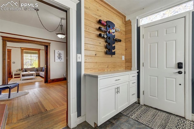 doorway to outside featuring wood walls