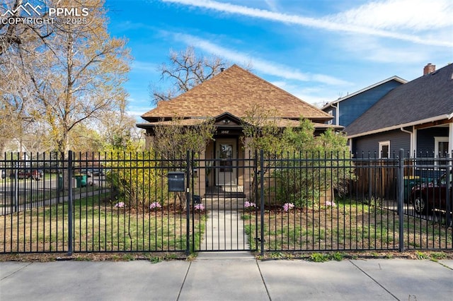 view of front of property with roof with shingles, a gate, and a fenced front yard