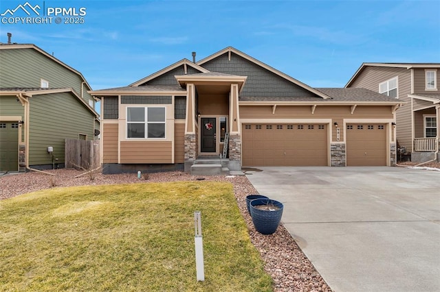 craftsman-style home with concrete driveway, fence, stone siding, a front lawn, and a garage