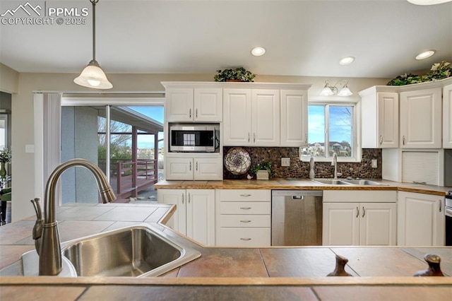 kitchen featuring a sink, appliances with stainless steel finishes, and a healthy amount of sunlight