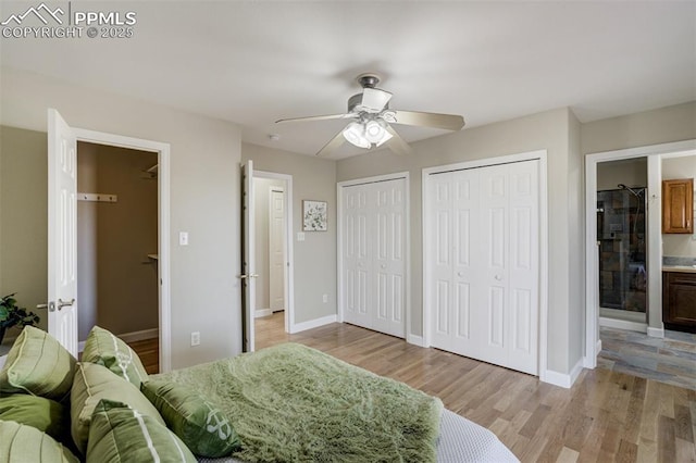 bedroom featuring baseboards, multiple closets, and light wood-style floors