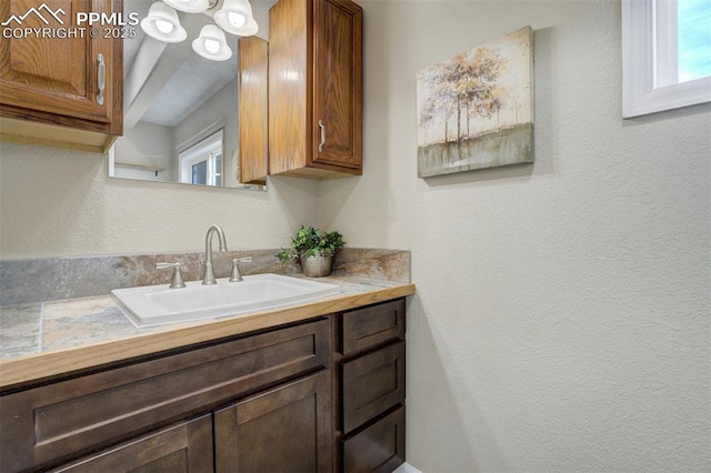 bathroom featuring a textured wall and vanity