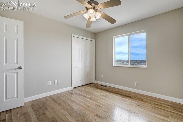 unfurnished bedroom with wood-type flooring, visible vents, and baseboards