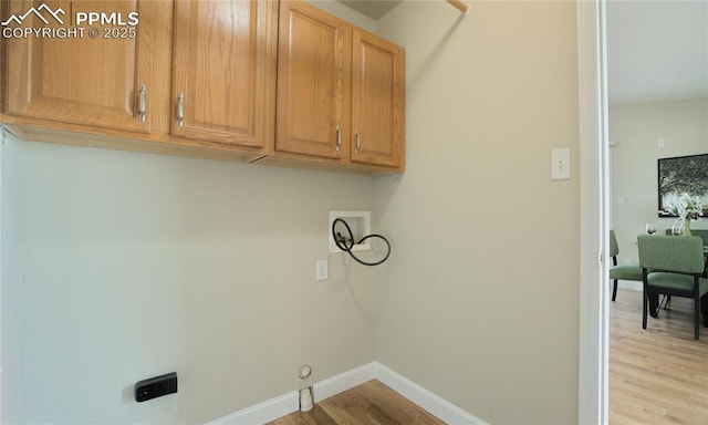 laundry room featuring cabinet space, washer hookup, baseboards, and wood finished floors
