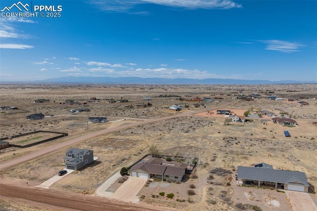 birds eye view of property featuring a mountain view, a desert view, and a rural view