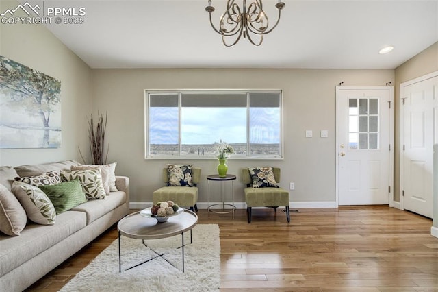 living room with recessed lighting, wood finished floors, baseboards, and a notable chandelier