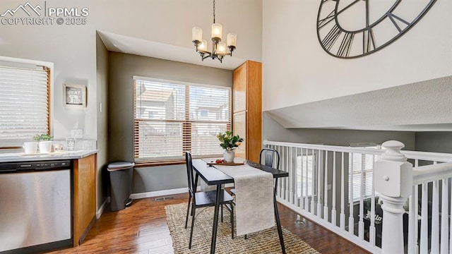 dining room with a high ceiling, wood finished floors, visible vents, baseboards, and a chandelier