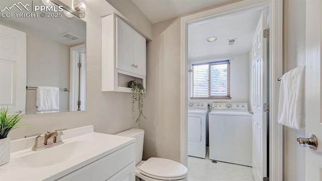 bathroom with visible vents, washing machine and clothes dryer, vanity, and toilet