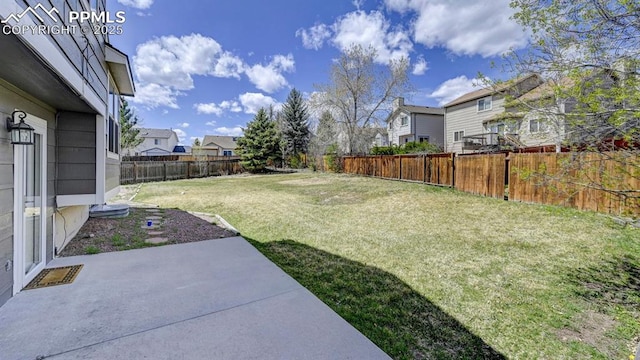 view of yard with a residential view, a patio area, and a fenced backyard